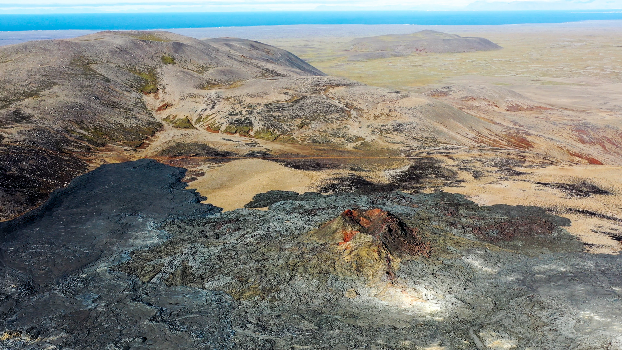 Jeden z kráterov v Geldingadalire a severný záver lávového poľa.