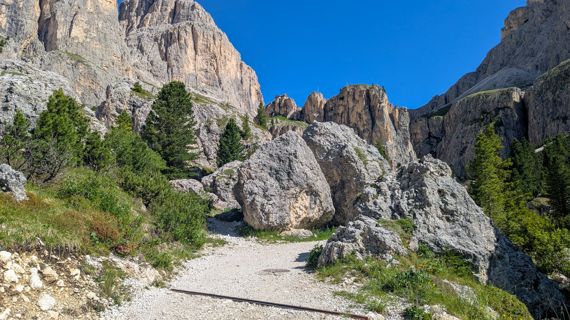 Chodník k Rifugio Vajolet – cesta vedie pomedzi skalné steny, ktoré pri východe slnka hrajú typickou červenkastou farbou „Rosengarten“.
