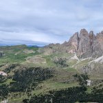 Foto 10: Panoramatický pohľad na skalné veže Odle (Fermeda) nad zelenými lúkami a lesmi popretkávanými chodníkmi.