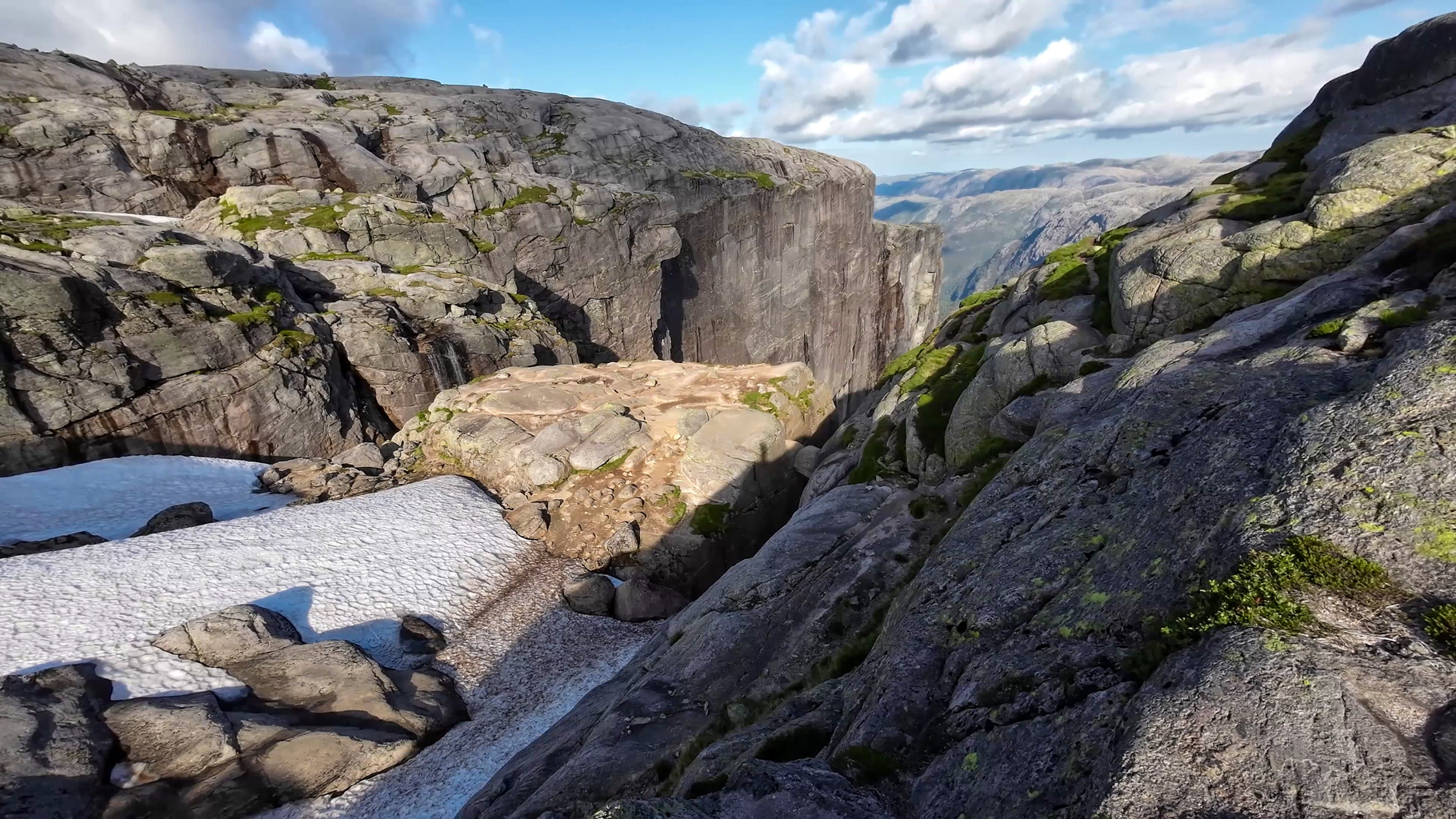 Prvý pohľad na Kjeragbolten – balvan zakliesnený medzi dvoma skalnými stenami, 984 metrov nad fjordom.