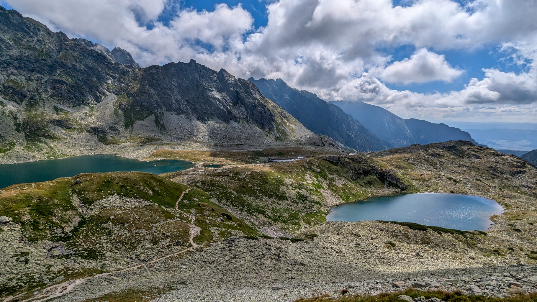 Malé a Veľké Hincovo pleso pohľadom z chodníka pod Kôprovským sedlom, obklopené skalnatými stenami Mengusovskej doliny.