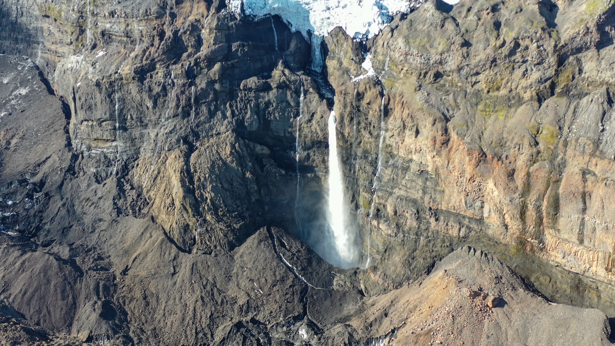 Vodopád Huldufoss. Pod ním sa nachádza ľadovec Huldujökull, ktorého povrch je tmavej fabry.