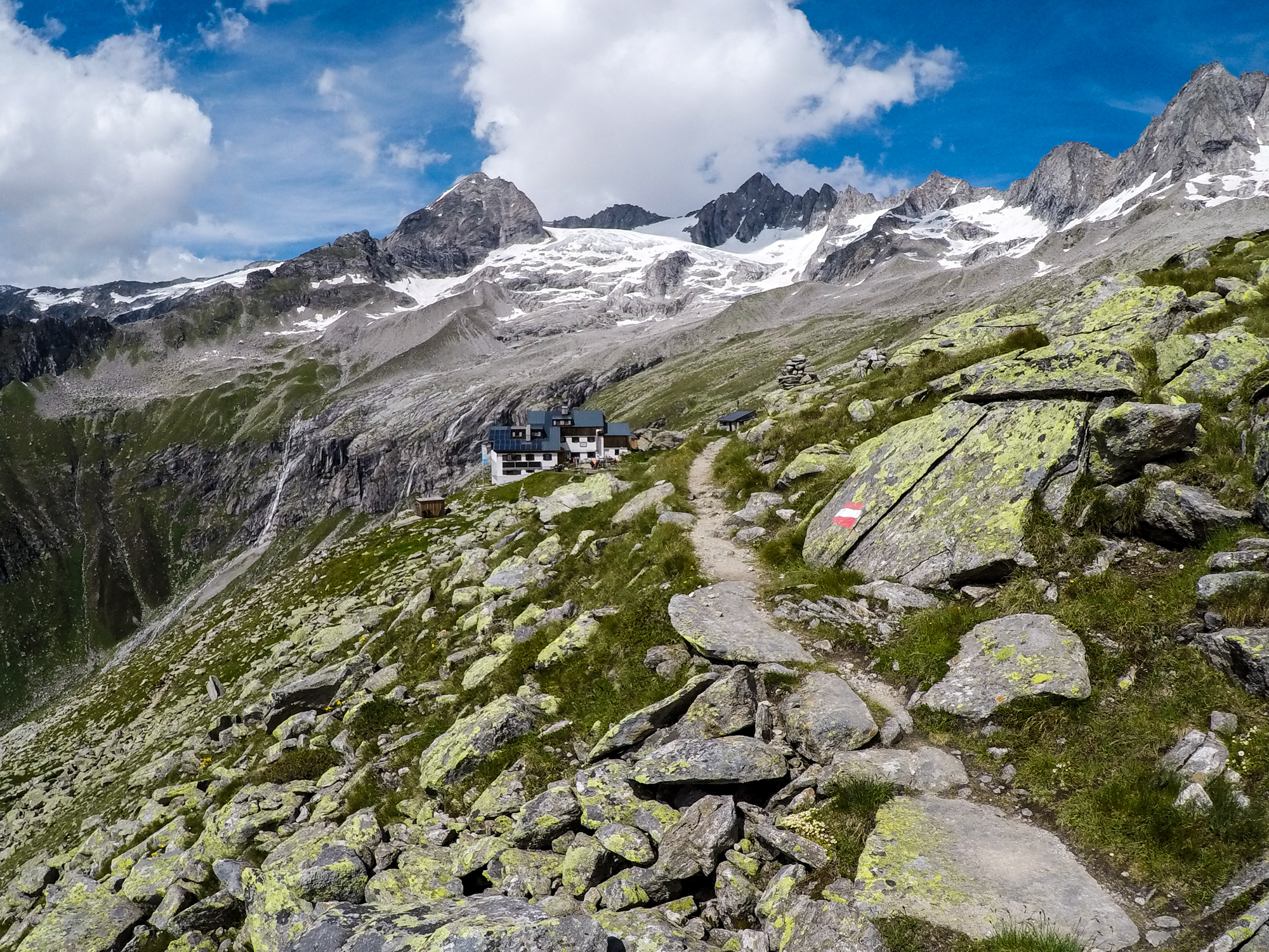 Plauener Hütte, nad ňou Wildgerlosspitze (3280 m), Reichenspitze (3303), Zillerspitze (3092) a Richterspitze (3052 m).