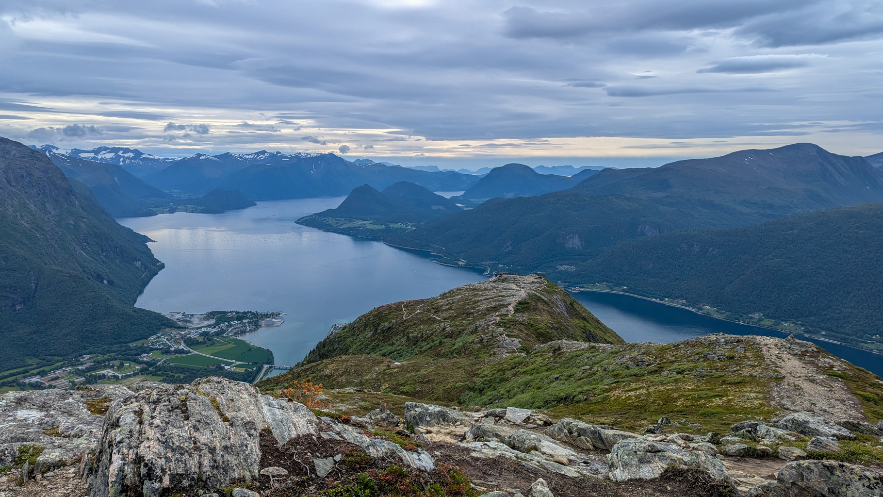 Pohľad na hlboké údolie Romsdalen z hrebeňa Romsdalseggen. Počas výstupu sa naskytujú výhľady na rieku
            Rauma aj dramatické štíty, ako napríklad Trollveggen či Romsdalshorn.
        
