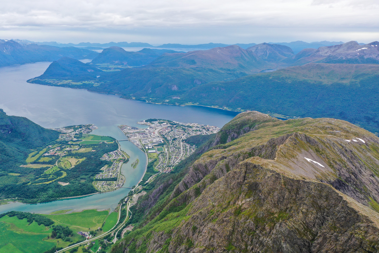 Letecký pohľad na Romsdalseggen, s kľukatým chodníkom vedúcim po ostrom hrebeni. Trasa je populárna pre
            svoju kombináciu exponovaných úsekov a panoramatických výhľadov.
        
