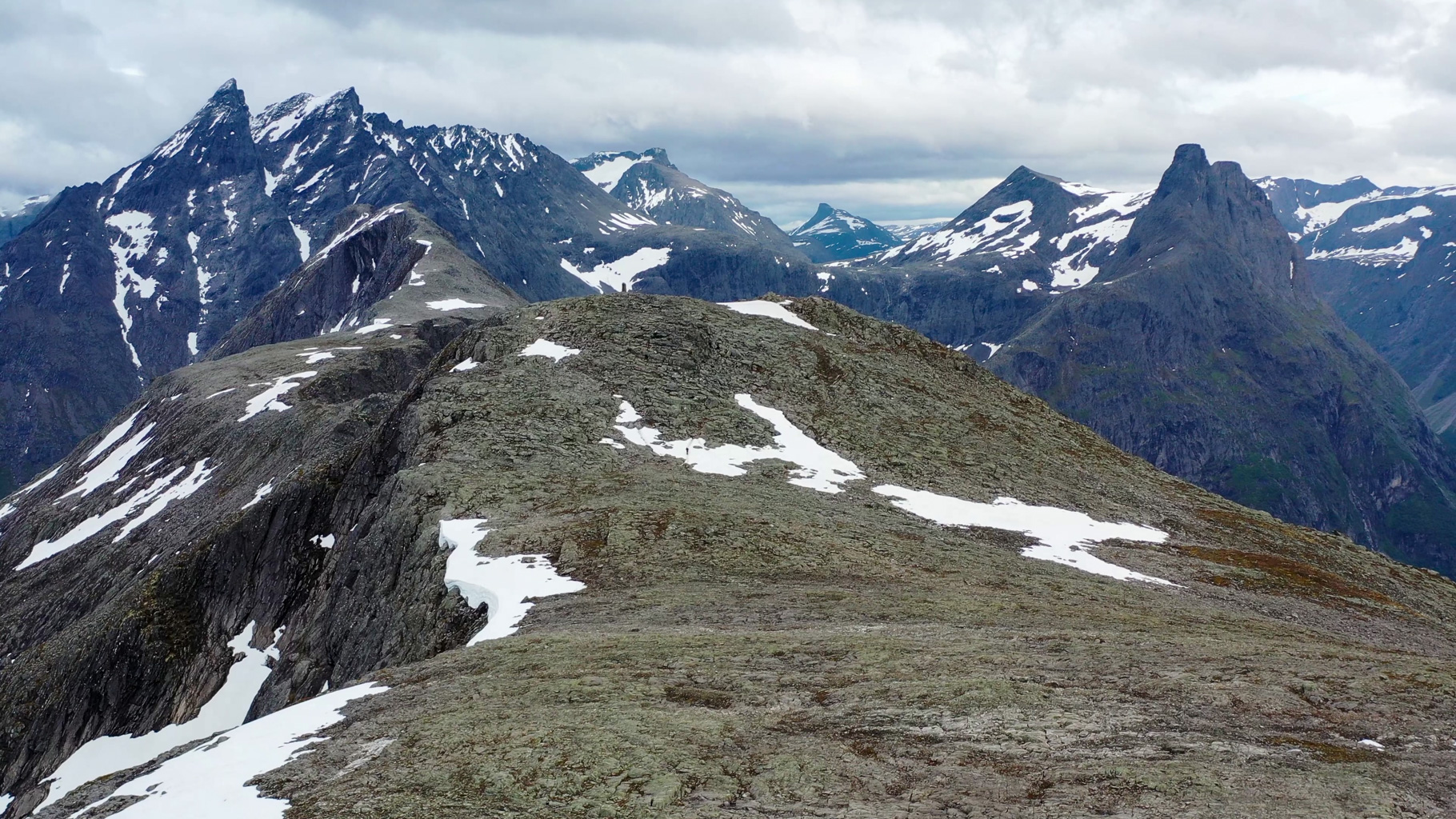 Zasnežené vrcholy. V popredí Mjølvafjellet (1216 m), za ním Blånebba (1320 m) a ikonický Romsdalshornet
            (1550 m), obľúbený medzi horolezcami.
        