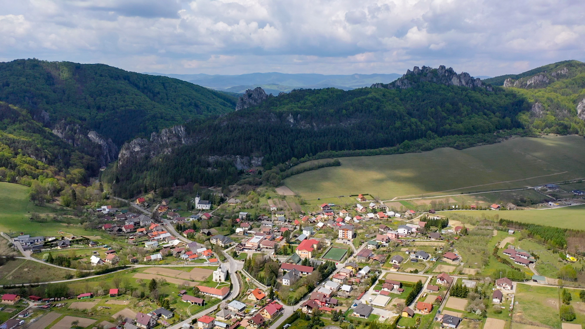 Dedina Súľov-Hradná, časť Súlov, v pozadí Súľovský hrad.