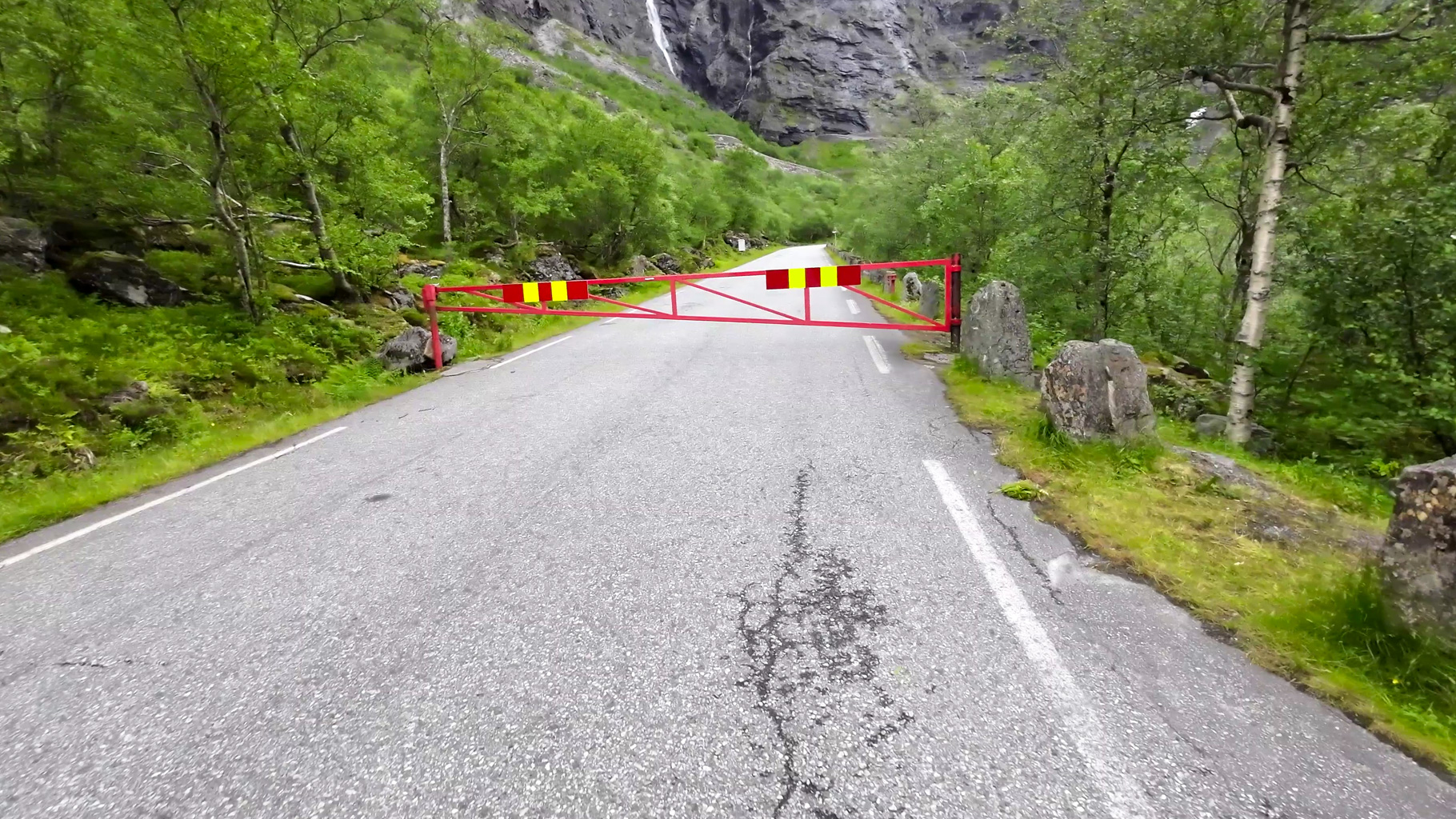 Uzavretý úsek cesty Trollstigen s rampou. Vstup na trasu je možný len pešo.
