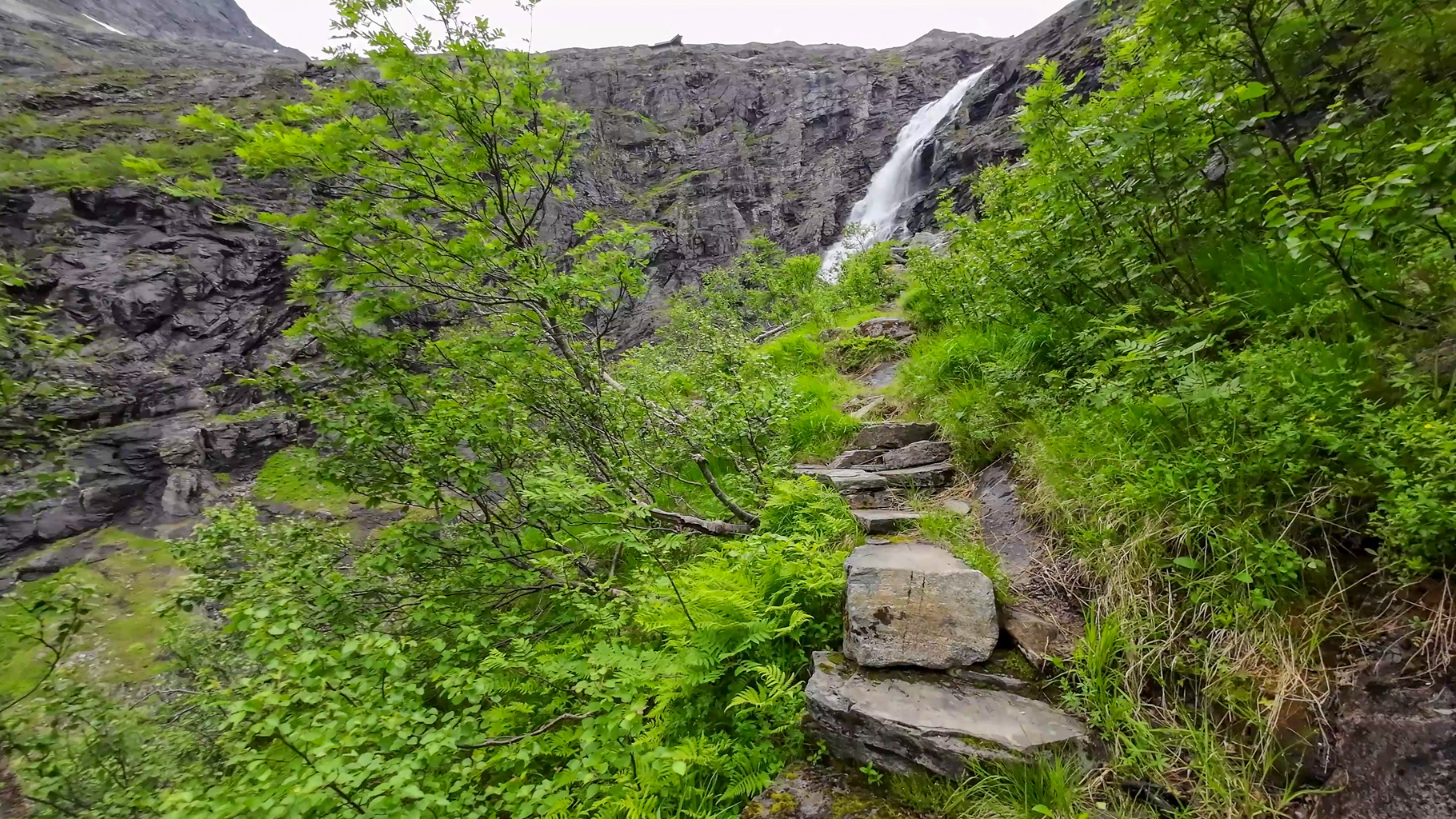 Stúpanie po horskom chodníku k turistickému centru Trollstigen.