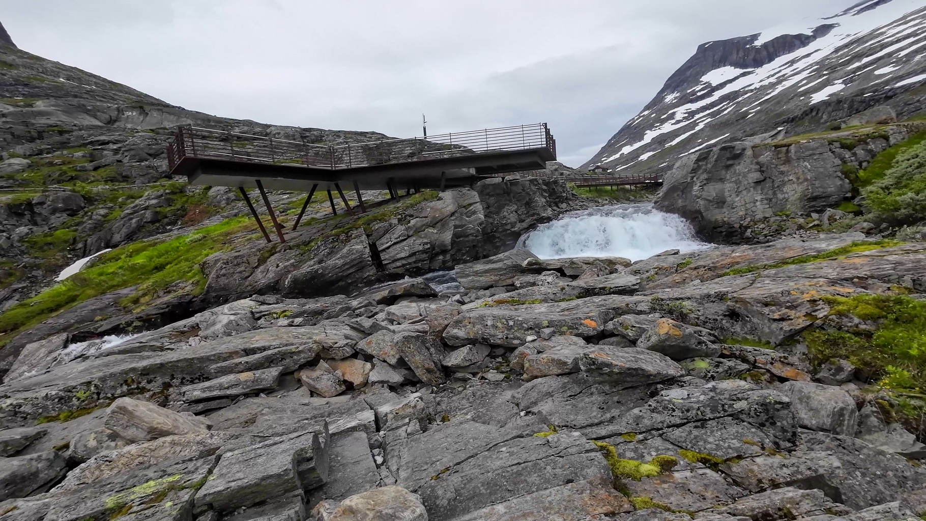 Vyhliadková plošina pri centre Trollstigen nad riekou a vodopádom.