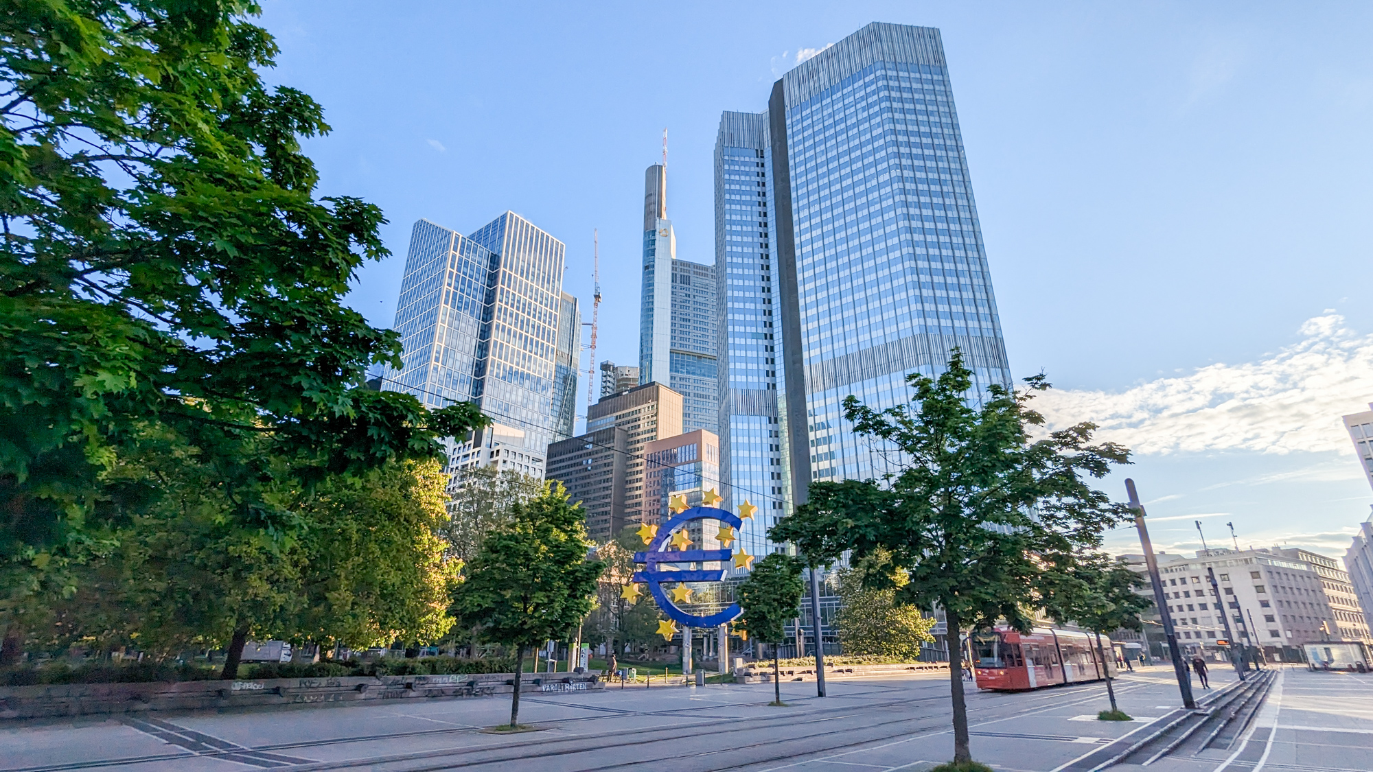 Mrakodrapy finančnej štvrte a ikonický symbol eura pred bývalým sídlom Európskej centrálnej banky na Willy-Brandt-Platz.