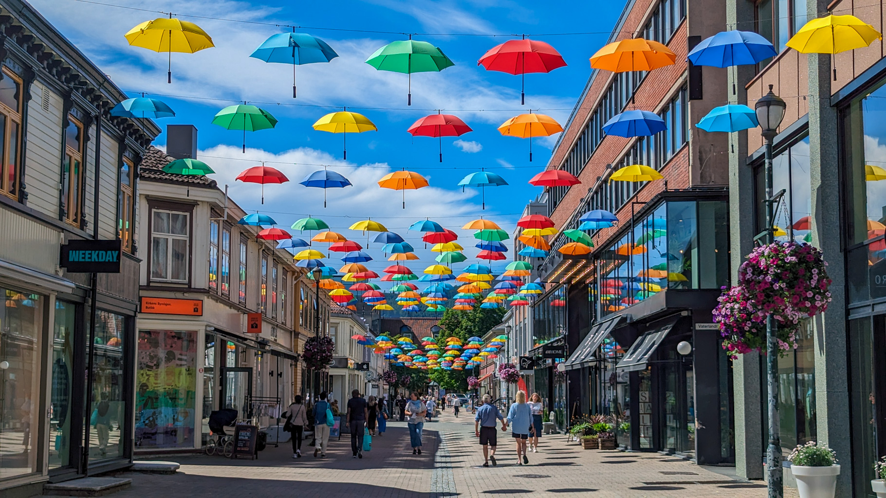 Farebné dáždniky nad pešou zónou v centre mesta vytvárajú veselú letnú atmosféru Trondheimu.