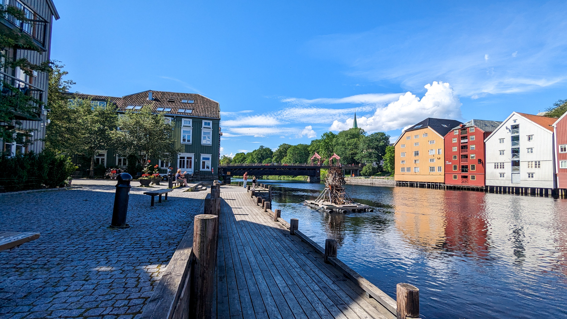 Pokojná promenáda pri rieke Nidelva, v pozadí starý most Gamle Bybro a Nidaroský dóm.