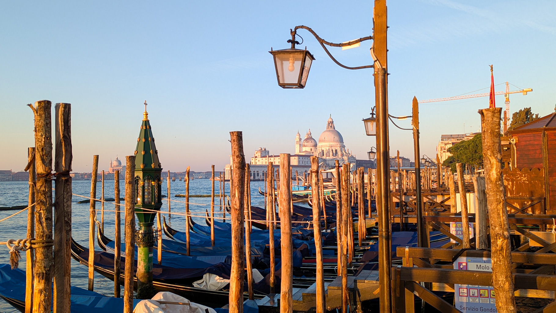 Ráno v Benátkach s pohľadom na Santa Maria della Salute a gondoly pripravené na plavby po Veľkom
            kanáli.
        